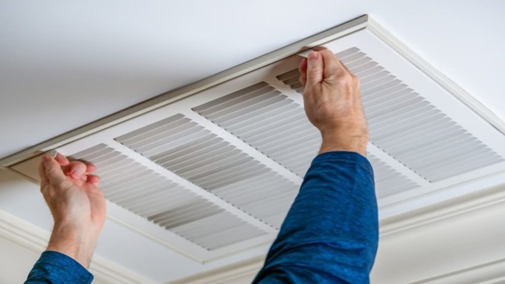 HVAC air filter being inspected by homeowner indoors